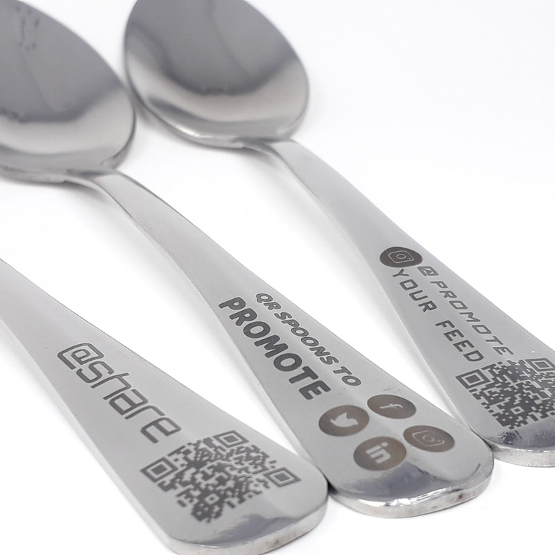 Another close-up of some teaspoons laser marked with business name, QR code and icons for facebook, twitter, instagram and LinkedIn socal media icons for business promotion purposes