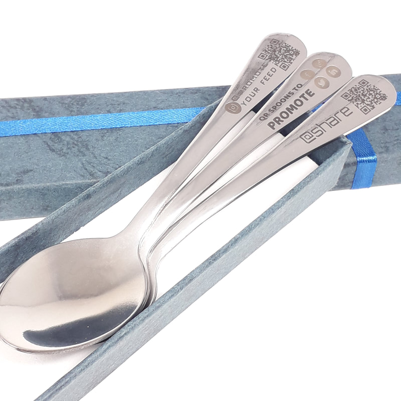 Shown in a luxury gift box. Another close-up of some teaspoons laser marked with business name, QR code and icons for facebook, twitter, instagram and LinkedIn socal media icons for business promotion purposes