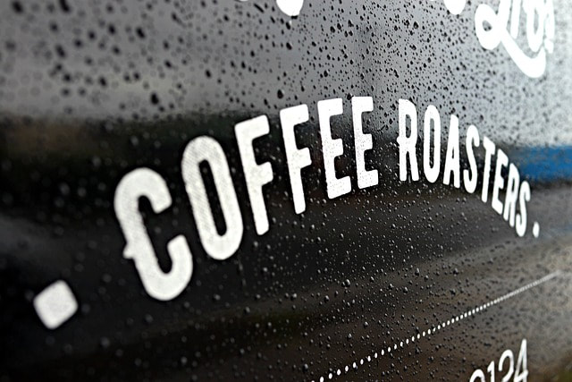 custom designed waterproof labels shown on a glass window outside a coffee shop in Inverness, Scotland